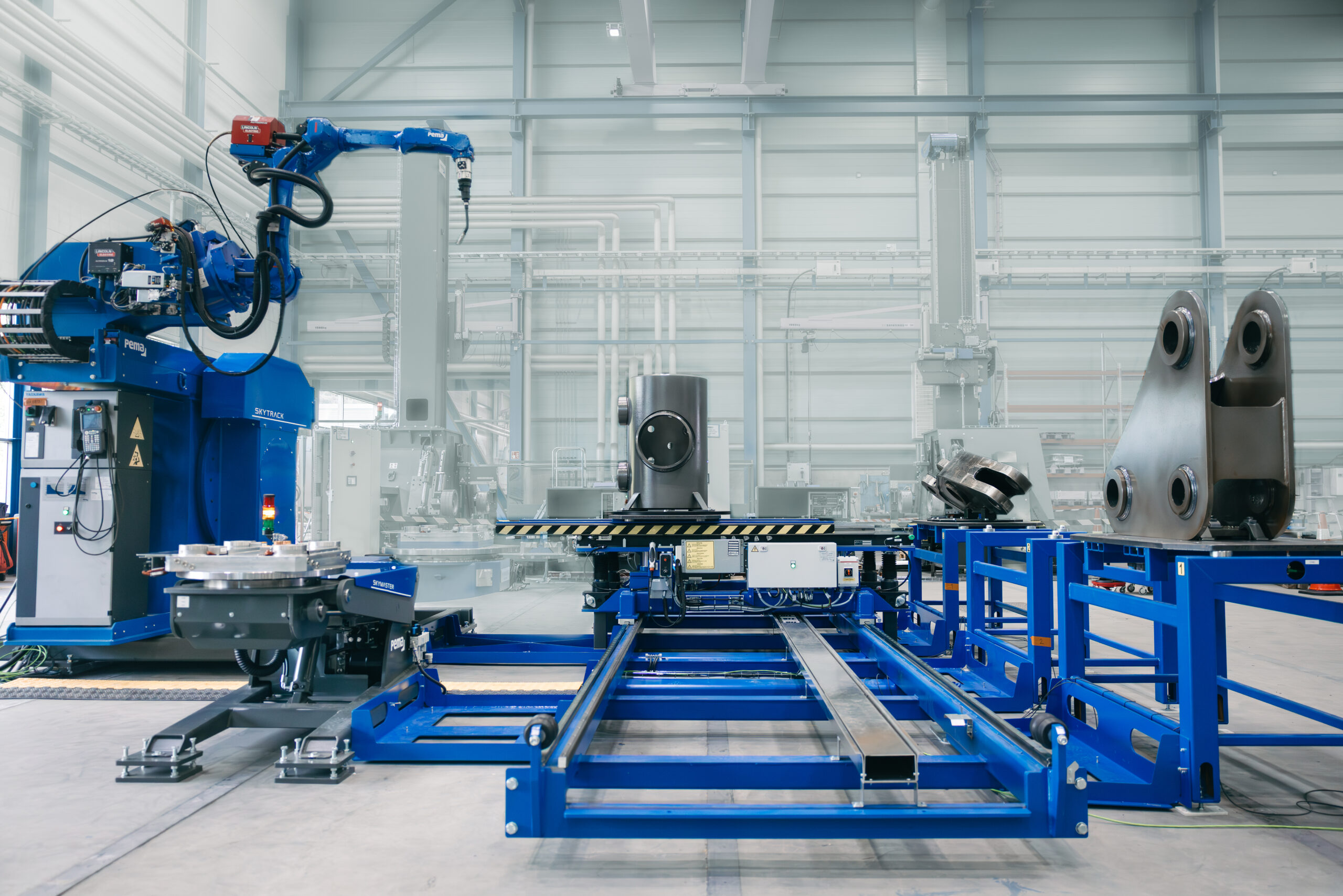 Flexible manufacturing system showing a PEMA welding robot, manual welding station and automated conveyer